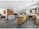 Spacious kitchen with gray tile floors, brick accent wall, island, white cabinets and stainless steel appliances at 6724 Brushwood Dr, Charlotte, NC 28262
