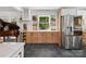 Kitchen with stainless steel refrigerator, beverage bar, piano, and view of backyard at 6724 Brushwood Dr, Charlotte, NC 28262