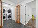 Well-lit laundry room with stacked washer and dryer units and modern fixtures at 6724 Brushwood Dr, Charlotte, NC 28262