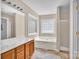Bright bathroom with a soaking tub, glass block window, and walk-in shower at 7536 Bimini Ct, Sherrills Ford, NC 28673
