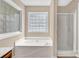 Bright bathroom featuring a soaking tub, glass block window, and shower at 7536 Bimini Ct, Sherrills Ford, NC 28673
