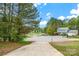 A charming two-story home sits at the end of a long gravel driveway, backed by lush trees at 7536 Bimini Ct, Sherrills Ford, NC 28673
