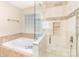 Bathroom featuring large tub with tile surround and glass enclosed shower at 7638 Carrington Forest Ln, Matthews, NC 28105