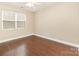 Bright bedroom featuring hardwood floors, a window, and neutral-colored walls at 7638 Carrington Forest Ln, Matthews, NC 28105
