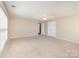 Spacious bedroom with neutral carpet, a ceiling fan, and two large windows at 7638 Carrington Forest Ln, Matthews, NC 28105