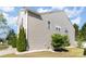 Side view of a two-story home with neutral siding, manicured landscaping, and a well-maintained lawn at 7638 Carrington Forest Ln, Matthews, NC 28105