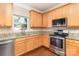 Modern kitchen featuring stainless steel appliances, granite countertops, and warm wood cabinetry at 7638 Carrington Forest Ln, Matthews, NC 28105