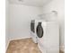 Bright laundry room featuring modern washer and dryer with tile flooring and wire shelving at 7638 Carrington Forest Ln, Matthews, NC 28105