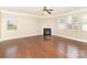 Open-concept living room with a fireplace, many windows, and hardwood floors at 7638 Carrington Forest Ln, Matthews, NC 28105