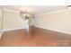 Spacious living room with hardwood floors, neutral paint, and a modern chandelier at 7638 Carrington Forest Ln, Matthews, NC 28105