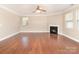 Cozy living room with hardwood floors, ceiling fan, and a gas fireplace with white mantel at 7638 Carrington Forest Ln, Matthews, NC 28105