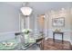 Bright dining room featuring a glass table, modern chairs, dark wood floors, elegant chandelier, and ample space at 8257 Legare Ct, Charlotte, NC 28210