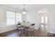 Bright dining room featuring a glass table, modern chairs, dark wood floors, and ample natural light at 8257 Legare Ct, Charlotte, NC 28210