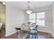 Bright dining room with a glass table, modern chairs, dark wood floors, elegant chandelier, and natural light at 8257 Legare Ct, Charlotte, NC 28210