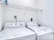 Bright laundry area with white washer and dryer set and wire shelving at 8257 Legare Ct, Charlotte, NC 28210