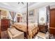 Elegant main bedroom with tray ceiling, four-poster bed, and warm natural light at 911 Earl St, Shelby, NC 28150