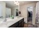 Well-lit bathroom featuring double sinks and a walk-in closet for extra storage at 9112 Avery Meadows Dr, Charlotte, NC 28216
