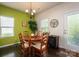 Sunny dining area with a wooden table, modern chandelier, and a view of the backyard through the windows at 9112 Avery Meadows Dr, Charlotte, NC 28216