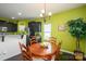 Cozy dining area features a wooden table, stylish chandelier, and bright green accent wall at 9112 Avery Meadows Dr, Charlotte, NC 28216