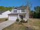 Charming two-story home with stone accents, vinyl siding, a white garage door, well-manicured front yard and small tree at 9112 Avery Meadows Dr, Charlotte, NC 28216