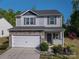 Charming two-story home with stone accents, vinyl siding, a white garage door, well-manicured front yard and wreath at 9112 Avery Meadows Dr, Charlotte, NC 28216