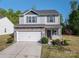 Charming two-story home with stone accents, vinyl siding, a white garage door, well-manicured front yard and wreath at 9112 Avery Meadows Dr, Charlotte, NC 28216