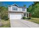 Charming two-story home with stone accents, vinyl siding, a white garage door and well-manicured front yard at 9112 Avery Meadows Dr, Charlotte, NC 28216