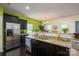 Open kitchen boasts granite counters, stainless fridge, and dark cabinetry for a modern and stylish space at 9112 Avery Meadows Dr, Charlotte, NC 28216