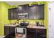 Updated kitchen with stainless oven, granite counters, dark cabinetry, and vibrant green accent wall at 9112 Avery Meadows Dr, Charlotte, NC 28216