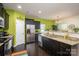 Well-lit kitchen with stainless fridge, granite counters, dark wood floors and cabinets at 9112 Avery Meadows Dr, Charlotte, NC 28216