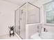 Bright bathroom featuring a glass enclosed shower, bathtub with tile surround, and a sunny window at 9208 Plashet Ln, Mint Hill, NC 28227