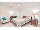 Charming bedroom featuring comfortable armchair, patterned bedding, and two side tables with bedside lamps at 9208 Plashet Ln, Mint Hill, NC 28227