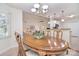 Dining room with wood table, chairs, chandelier, and bright windows with views into the living room at 9208 Plashet Ln, Mint Hill, NC 28227