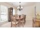 Traditional dining room showcasing a wooden table, chairs, grandfather clock, and a chandelier at 9208 Plashet Ln, Mint Hill, NC 28227