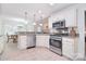Kitchen featuring stainless steel appliances, range hood, pendant lighting, and tile flooring at 9208 Plashet Ln, Mint Hill, NC 28227