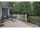 Outdoor patio with a table and chairs surrounded by a white fence and lush greenery at 9208 Plashet Ln, Mint Hill, NC 28227