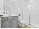 Neutral bathroom with a glass enclosed walk in shower, gray cabinets, and a sleek mirror at 921 E 36Th St, Charlotte, NC 28205