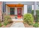 Inviting covered front porch with a vibrant red door, offering curb appeal and charm at 921 E 36Th St, Charlotte, NC 28205