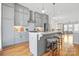 Open kitchen with gray cabinets, stainless appliances, island with seating, and modern lighting at 921 E 36Th St, Charlotte, NC 28205