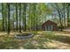 Backyard with lush trees and detached garage with firepit in a parklike setting at 127 Fantasy Ln, Mooresville, NC 28117