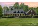 Charming brick home featuring a landscaped yard, dormer windows, and inviting front porch, perfect for enjoying the outdoors at 127 Fantasy Ln, Mooresville, NC 28117