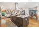 Kitchen island with marble counters, modern hood, and view to living area at 127 Fantasy Ln, Mooresville, NC 28117