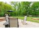 Spacious backyard with a stone patio and outdoor furniture, surrounded by lush trees at 13228 Crooked Pine Ct, Charlotte, NC 28215