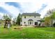 Expansive backyard featuring a two-story home, patio, playground, and a large grassy area at 13228 Crooked Pine Ct, Charlotte, NC 28215