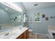 Bright bathroom featuring double sinks, a large mirror, and a window for natural light at 13228 Crooked Pine Ct, Charlotte, NC 28215