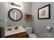 Cozy half bathroom with an oval mirror, single vanity, and neutral wall paint at 13228 Crooked Pine Ct, Charlotte, NC 28215