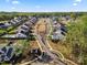 An aerial view shows homes in a neighborhood with sidewalks and manicured lawns surrounded by trees at 14013 Pinoli Pine Cir, Huntersville, NC 28078