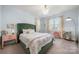 Bright bedroom features a green padded headboard, designer curtains and modern lighting at 14013 Pinoli Pine Cir, Huntersville, NC 28078