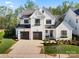 Beautiful new construction farmhouse-style home featuring a two-car garage and a landscaped front yard at 14013 Pinoli Pine Cir, Huntersville, NC 28078
