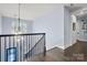 Bright upstairs hallway with hardwood floors and staircase view at 14013 Pinoli Pine Cir, Huntersville, NC 28078